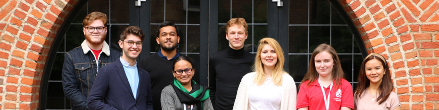 group of people pose for photo outside library